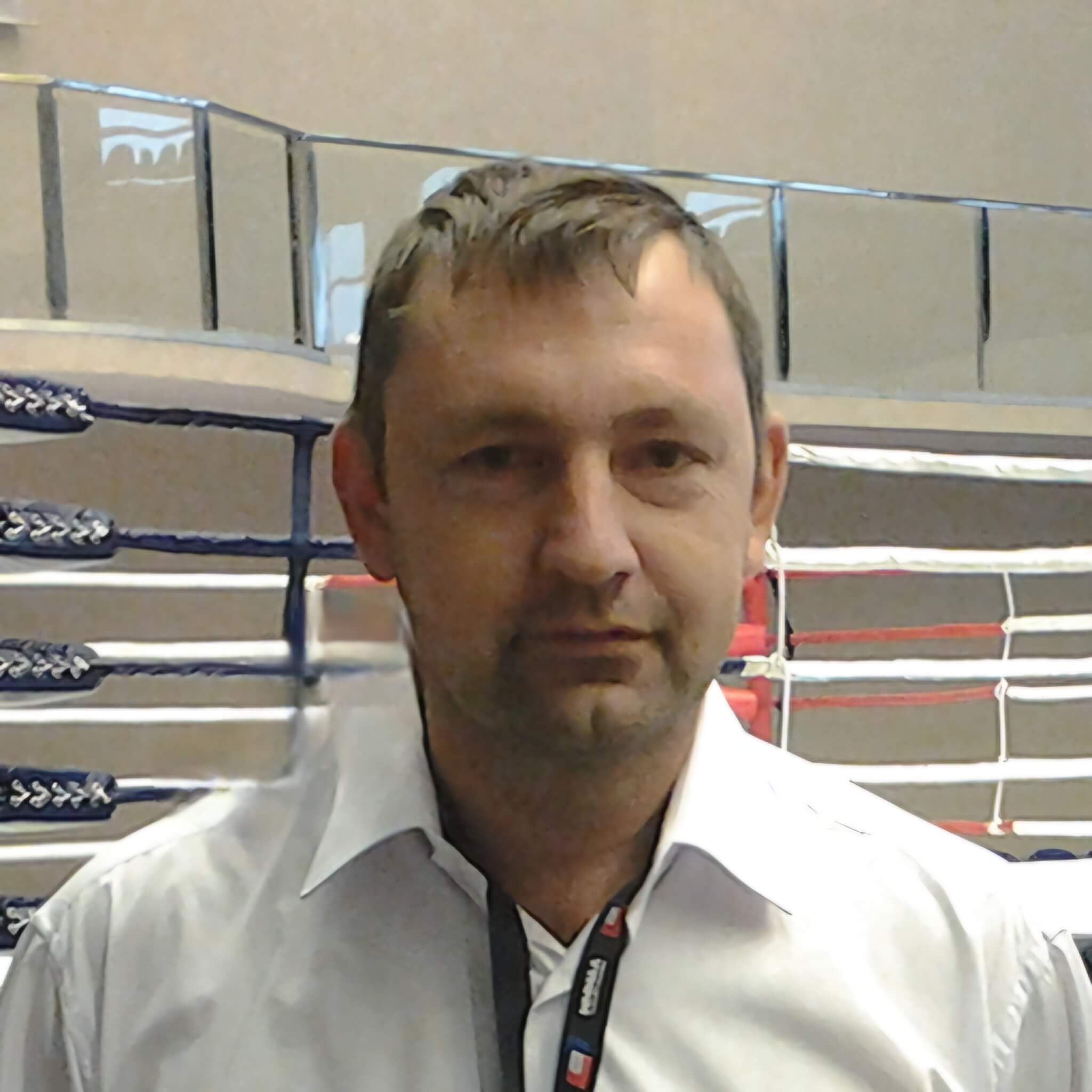 Главный тренер Игорь Михайлович Шай на фоне символики спортивного клуба «Щит и Меч».